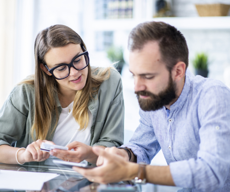A young couple in Winchester, MA, reviewing their insurance policy and financial plans together on a tablet